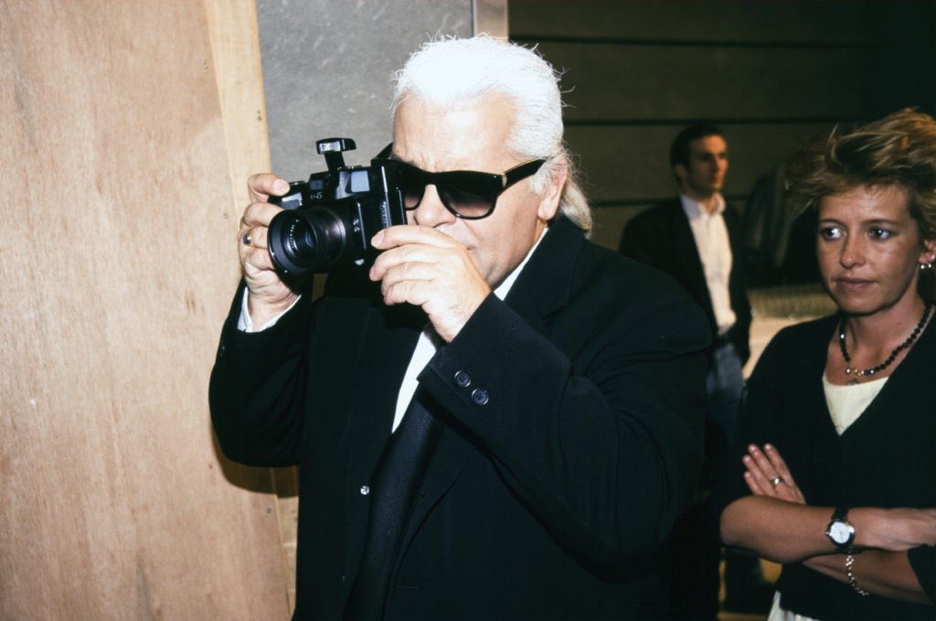 Karl Lagerfeld et son appareil photo lors du défilé Chloé, Prêt-à-Porter, collection Automne-Hiver 1997-98 à Paris en mars 1997, France. (Photo by PAT/ARNAL/Gamma-Rapho via Getty Images)
