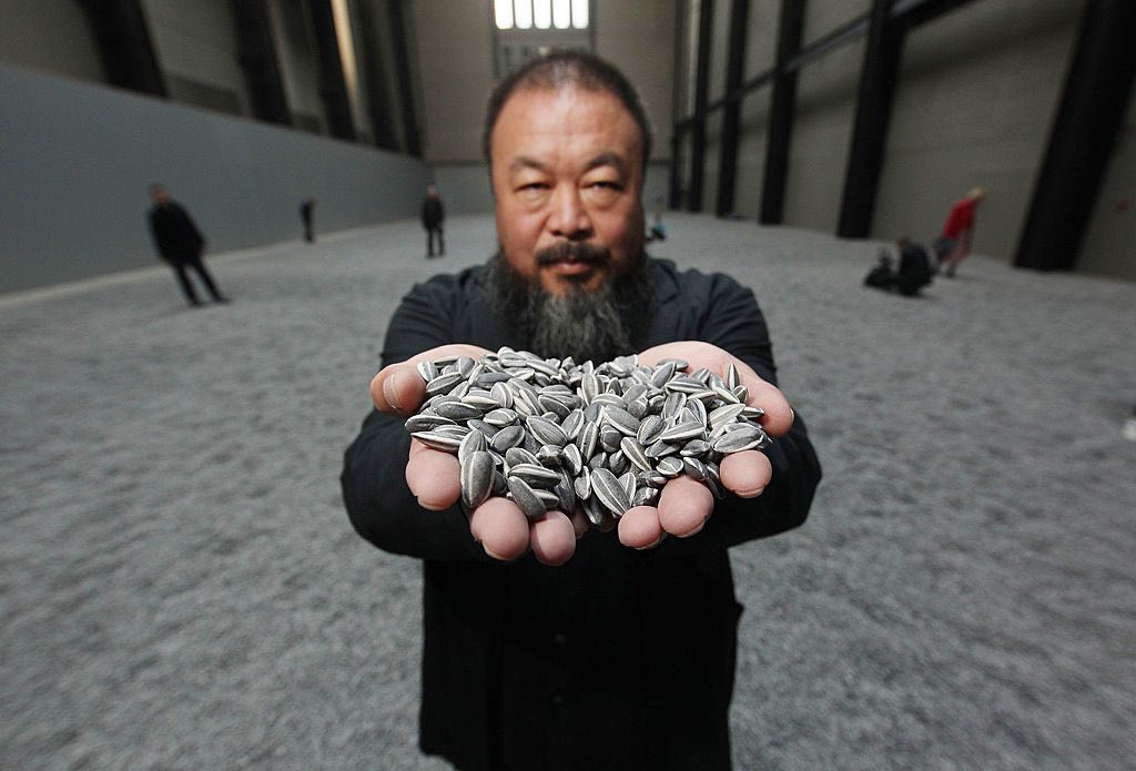 LONDON, ENGLAND - OCTOBER 11:  Chinese Artist Ai Weiwei holds some seeds from his Unilever Installation 'Sunflower Seeds'  at The Tate Modern on October 11, 2010 in London, England. The sculptural installation comprises 100 million handmade porcelain replica sunflower seeds. Visitors to the Turbine Hall  will be able to walk on the work - which opens on October 12, 2010 and runs until May 2, 2011.  (Photo by Peter Macdiarmid/Getty Images)